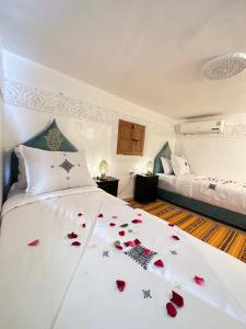 um quarto com uma cama com rosas vermelhas em Dar Khmissa Fes em Fez