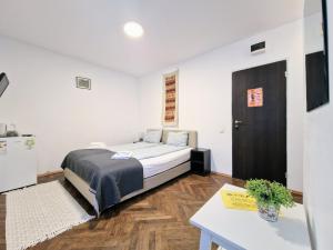 a bedroom with a bed and a table in it at Main Square Apartments & More in Braşov
