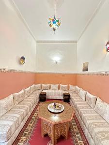 sala de estar con sofá grande y mesa en Dar Khmissa Fes, en Fez
