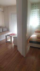 a room with a bed and a living room with a table at Apartman Borko 2-1 in Loznica