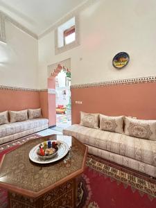 een woonkamer met een bank en een tafel bij Dar Khmissa Fes in Fès