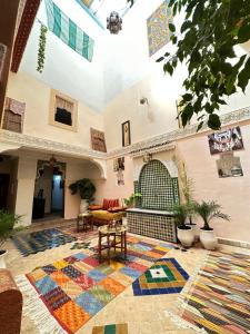 Dar Khmissa Fes في فاس: غرفة معيشة مع سجادة ملونة على الأرض