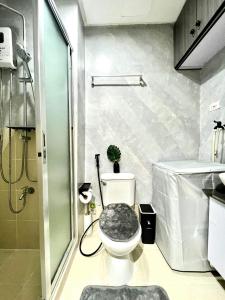 La salle de bains est pourvue d'une douche et de toilettes. dans l'établissement JA2 STAYCATION @TREES RESIDENCES, à Manille