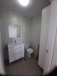 a bathroom with a toilet and a sink and a mirror at casa paradisiaca in Murcia
