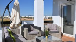 a patio with two chairs and a table and a umbrella at casa paradisiaca in Murcia