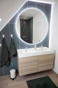 bagno con lavandino e grande specchio di Appartement centre - La Gacilly a La Gacilly