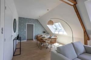 un soggiorno con tavolo, sedie e divano di Appartement centre - La Gacilly a La Gacilly