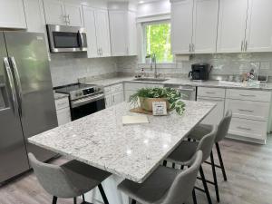 a kitchen with a granite counter top island with chairs at Gardner Lake 2 Queen/1King/2 Bath/Laundry- Private in Salem