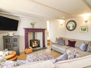 a living room with a couch and a fireplace at Hillside in Torpoint