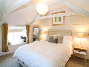 a bedroom with a large white bed and a window at Hillside in Torpoint