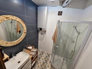 a bathroom with a shower and a sink and a mirror at Apartament w Centrum in Żuromin +13 photos