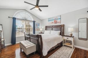 a bedroom with a bed and a ceiling fan at PCB Beach House minutes from fun! in Panama City Beach
