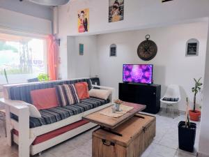 sala de estar con sofá y TV en la casa de gales habitación privada con baño en Puerto Madryn