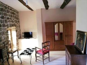 a living room with two chairs and a stone wall at Maison de charme à Saint-Andéol-de-Vals avec vue sur la montagne in Saint-Andéol-de-Vals