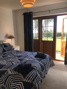 a bedroom with two beds and a sliding glass door at Kesh Lakeside Cottage in Kesh