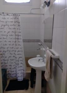 baño con lavabo y cortina de ducha en la casa de gales habitación privada con baño en Puerto Madryn