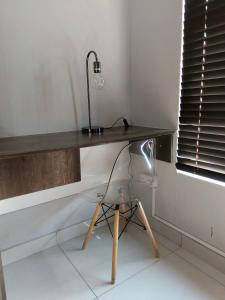a desk with a lamp and a chair in a room at Olive Exclusive in Gaborone +22 photos