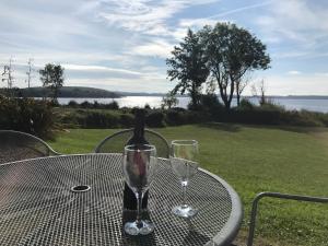 a bottle of wine sitting on a table with two glasses at Kesh Lakeside Cottage in Kesh