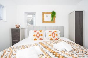 a white bedroom with a large bed with pillows at Southend Serenity 2-Bedroom Flat - Southend Stays in Southend-on-Sea