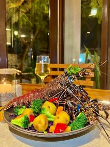 a plate of vegetables on a table with a glass of wine at Hotel La Isla in Puerto Ayora