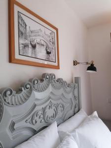 Un dormitorio con una cama blanca con una foto en la pared en Casa da Canada da Fajã, en Feteira