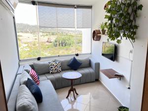 a living room with a couch and a table at The PEARL of ACHAKAR , your 5 STAR cozy apartment in Tangier