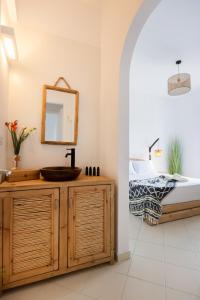 ein Bad mit einem Waschbecken und einem Bett in der Unterkunft Acoya Residences in Aliki