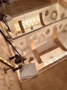 a bathtub in a bathroom with a towel in it at Chasa de Capol - Historische Gaststätte & Weinkellerei in Sta Maria Val Müstair