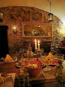 a table with candles and wine glasses on it at Chasa de Capol - Historische Gaststätte & Weinkellerei in Santa Maria Val Müstair