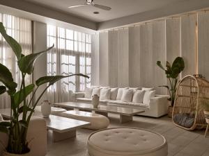 a living room with a white couch and a table at The Bay Hotel & Suites in Vasilikos