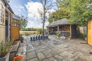 a patio with a giant chessboard in front of a building at Relaxing Retreat - The Shepherds Hut - Hot Tub in White Waltham