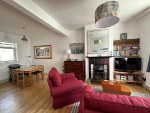 a living room with a red couch and a table at Beautiful Victorian house in central Cambridge in Cambridge