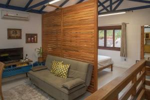 uma sala de estar com um sofá e um quarto em LOCAR-IN GRAMADO - Loft a 50 m da Rua Coberta em Gramado