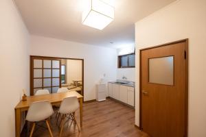 a kitchen and dining room with a wooden table and chairs at sumica apartments in Nikko