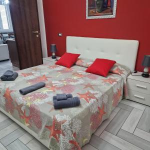 Un dormitorio con una cama con dos almohadas rojas. en Le Campanelle, en Alghero