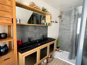 een badkamer met een zwarte wastafel en een douche bij La Rive - Charmant logement bord de Marne in Champigny-sur-Marne