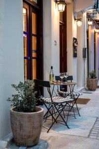 a patio with a table and chairs and a plant at Isioni Pension in Nafplio