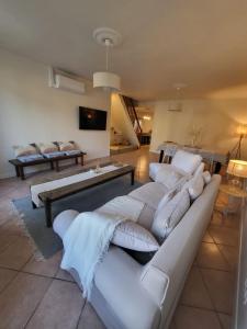 sala de estar con sofás blancos y TV en L'OREE DES LACS, Maison de village tout confort en Radonvilliers
