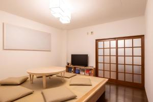a living room with a table and a tv at sumica apartments in Nikko