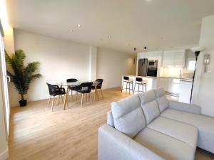 uma sala de estar com um sofá e uma mesa com cadeiras em Puertollano Central Park - by Pro Apartments em Puertollano