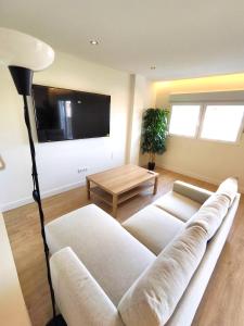 a living room with a couch and a flat screen tv at Puertollano Central Park - by Pro Apartments - Free Parking in Puertollano
