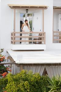 a bride standing on the balcony of a house at Acoya Residences in Aliki