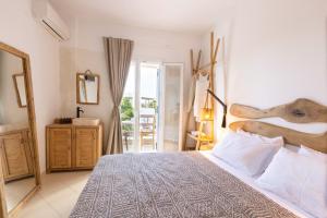 a bedroom with a large bed and a balcony at Acoya Residences in Aliki
