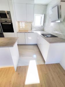 a white kitchen with a sink and a stove at Puertollano Central Park - by Pro Apartments in Puertollano
