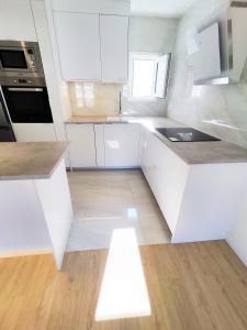 a white kitchen with a sink and a stove at Puertollano Central Park - by Pro Apartments - Free Parking in Puertollano