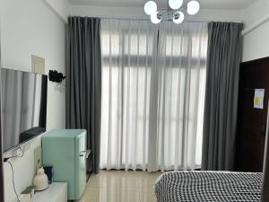 a bedroom with a bed and a window with curtains at 金門且停民宿 可包棟 好停車 近市區 in Jinning
