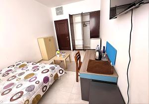 1 dormitorio con cama y escritorio. en Corniche AD - Extremely Unique Room, en Abu Dabi