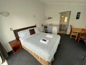 a bedroom with a bed with a tray on it at Ace Motor Lodge in Rotorua