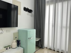 a blue refrigerator in a room with a tv at 金門且停民宿 可包棟 好停車 近市區 in Jinning