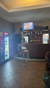 a restaurant with two chairs and a bar with a tv at Paradize in Daugavpils